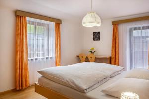 a bedroom with two white beds and orange curtains at Stablerhof Apt Löwenzahn in Cornedo all'Isarco