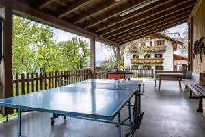 a ping pong table on the patio of a house at Stablerhof Apt Löwenzahn in Cornedo all'Isarco