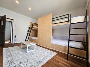 a bedroom with bunk beds and a table at Kuro in Hakodate