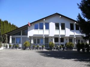 a white building with potted plants in front of it at Fewo Eg Mitte - Hunde erlaubt in Oberteuringen