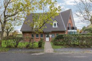 a red brick house with a black roof at Ferienwohnung Ulstrup in Böhl