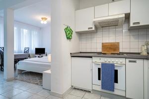 a kitchen with a stove top oven next to a living room at Fewo Eg Mitte - Hunde erlaubt in Oberteuringen