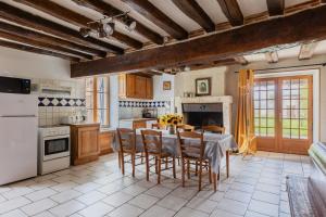 a kitchen with a table and chairs in a room at Gîte des Aulneaux in Fresnes