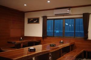a dining room with wooden tables and a large window at Emporium Chiangmai in Chiang Mai