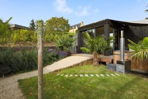 a black house in a garden with plants at Ecolodge à 300m de la plage in Pléneuf-Val-André