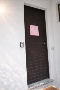 a black door with a pink sign on it at Emilia's Lakeview Terrace in Brienno
