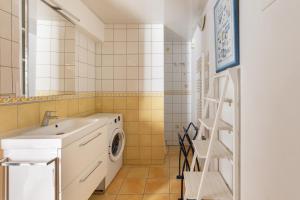 a bathroom with a sink and a washing machine at Gîte des Aulneaux in Fresnes