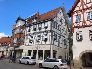 two cars parked in front of a large building at Ferienwohnung Luise in Münsingen