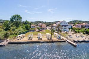 a resort with a dock with chairs and tables in the water at Saint Peter Bay - Basic Room in Kavos