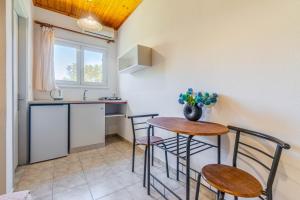 a kitchen with a table and chairs and a sink at Saint Peter Bay - Basic Room in Kavos