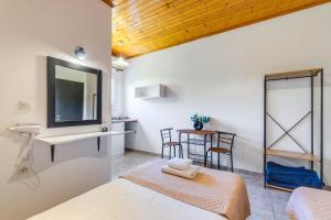 a room with a bed and a sink and a table at Saint Peter Bay - Basic Room in Kavos