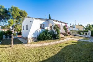 a white house with a fence and a yard at Coma-ruga in El Vendrell