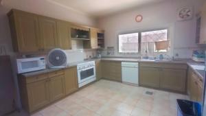 a large kitchen with wooden cabinets and white appliances at Hurghada Beach House in Hurghada