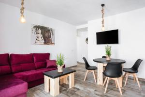 a living room with a purple couch and a table at Casa Bombón in Vejer de la Frontera