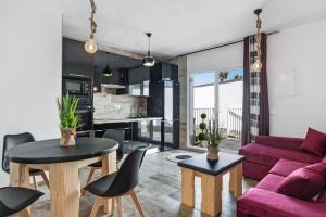 a living room with a purple couch and tables at Casa Bombón in Vejer de la Frontera