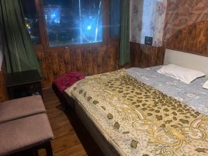 a bedroom with a bed and a window at R Krishna Hotel in Srinagar