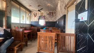 a dining room with wooden tables and chairs at R Krishna Hotel in Srinagar