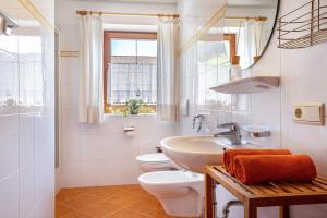 a white bathroom with a sink and a toilet at Mongaduierhof Apt Panorama in Umes +25 photos