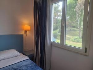 a bedroom with a bed and a large window at Helion Resort in Gouvia