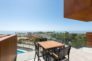 a table and chairs on a balcony with a view of the ocean at Adhara 053 in Torre del Mar