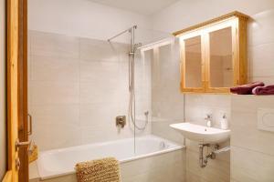 a bathroom with a tub and a sink and a shower at Berghex in Garmisch-Partenkirchen +16 photos