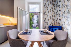 a kitchen with a table and chairs with cups on it at Lierna amorevole dimora in Lecco in Lecco +8 photos