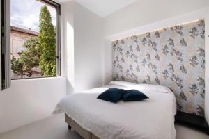 a bedroom with a bed with a large window at Lierna amorevole dimora in Lecco in Lecco