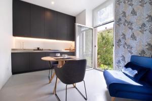 a kitchen and living room with a table and a blue couch at Lierna amorevole dimora in Lecco in Lecco