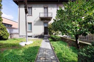 a walkway in front of a house with a tree at Lierna amorevole dimora in Lecco in Lecco