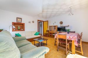 a living room with a couch and a table at Es Jaç in Cala Llombards