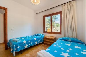 a bedroom with two beds and a window at Es Jaç in Cala Llombards