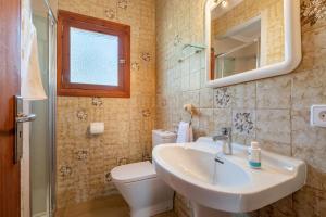 a bathroom with a sink and a toilet and a mirror at Es Jaç in Cala Llombards +17 photos