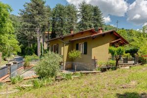 a small yellow house in the middle of a yard at Gigli di Firenze in Rufina