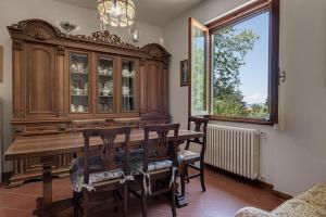 a dining room with a wooden dining table and a window at Gigli di Firenze in Rufina