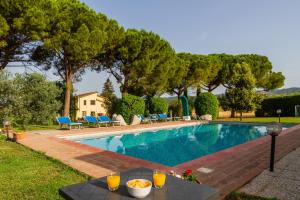 a swimming pool with a table with orange juice on it at Capracotta - Sole in Montemassi