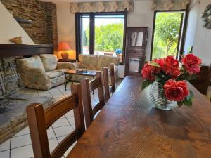 a living room with a vase of red flowers on a wooden table at Villino Le Ortensie in Stintino +39 photos