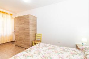 a bedroom with a bed and a wooden cabinet at Sea Shell Isola Rossa in Isola Rossa