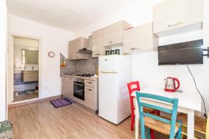 a kitchen with a white refrigerator and a table at Sea Shell Isola Rossa in Isola Rossa
