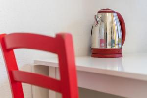 a red chair sitting on a shelf with a tea pot at Sea Shell Isola Rossa in Isola Rossa