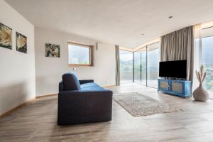 a living room with a couch and a television at Aumia Apartment Saphir in Völs am Schlern