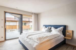 a bedroom with a large bed and a large window at Aumia Apartment Saphir in Völs am Schlern