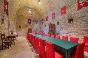 a large room with a long table and red chairs at Castello di Magrano in Gubbio