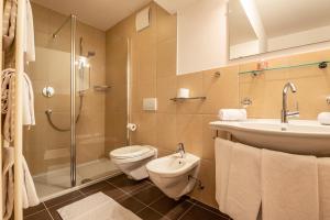 a bathroom with a toilet and a sink and a shower at Sabina Dolomites Joch in Alpe di Siusi +10 photos