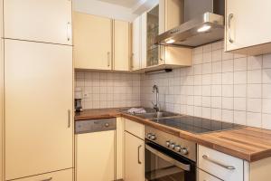 a kitchen with white cabinets and a sink at Sabina Dolomites Joch in Alpe di Siusi