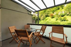 a patio with four chairs and a table on a balcony at Alte Stadtvilla am Weinberg 1 in Traben-Trarbach