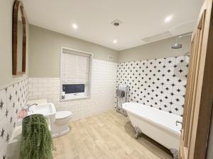 a bathroom with a tub and a toilet and a sink at The Hideout in Southampton
