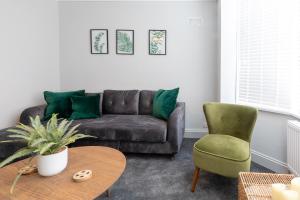 a living room with a brown couch and a green chair at The Hideout in Southampton +9 photos