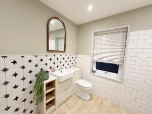 a bathroom with a toilet and a sink and a mirror at The Hideout in Southampton