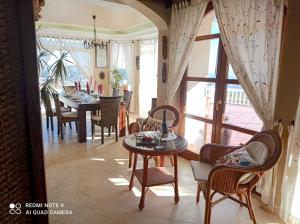 a living room with a table and chairs and a dining room at La huerta de Bonela in Casarabonela