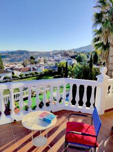 a balcony with a table and a white railing at La huerta de Bonela in Casarabonela